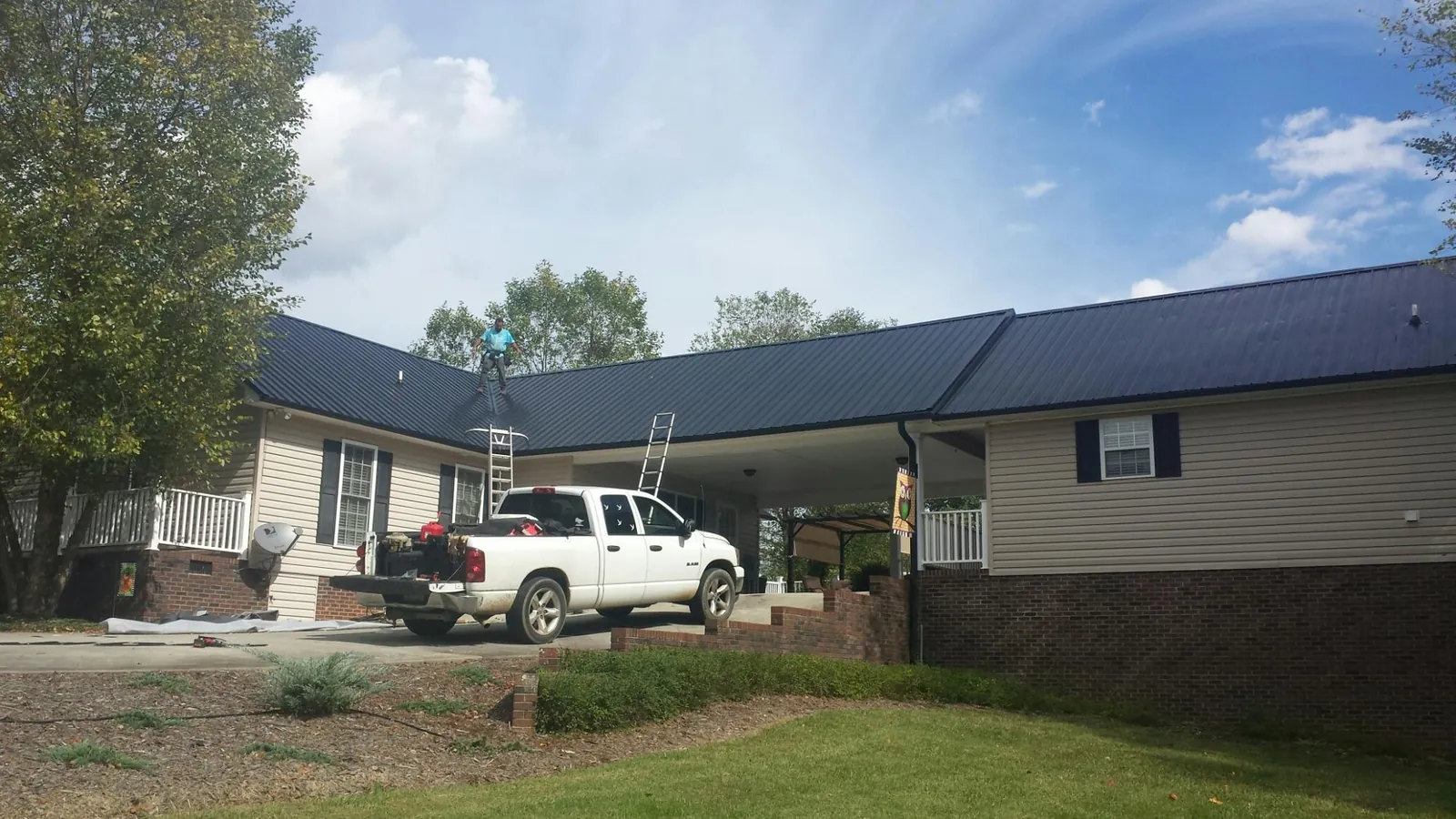 Black metal roof over a home and attached breezeway with ladders set in Vacaville