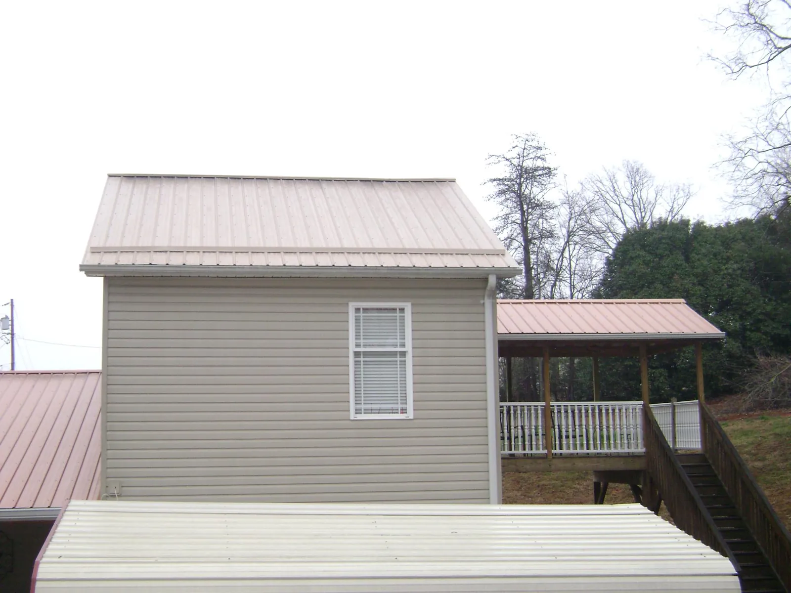 Tan metal roofs on a two story addition and attached porch, from a Roof Replacement job in Vacaville